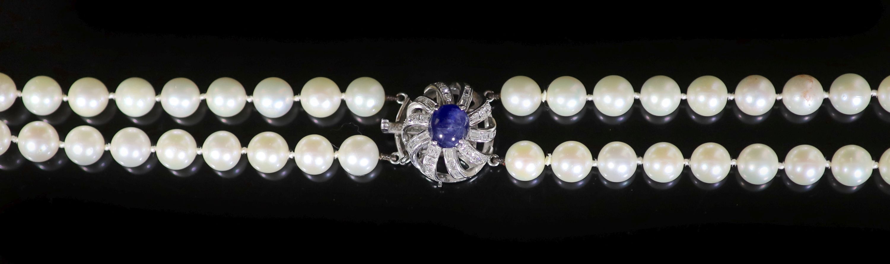 A two-row uniform cultured pearl necklace with 14K white gold, sapphire and diamond set flower clasp,